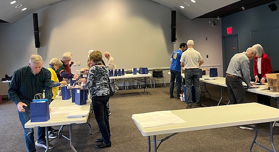 A group of people working at tables.