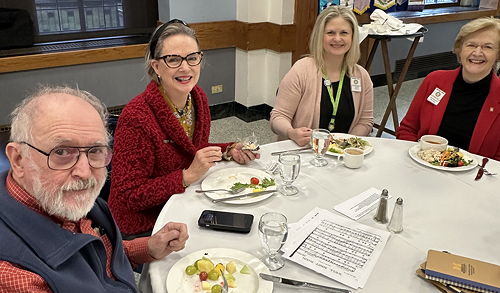 Four Rotarians sitting at a lunch table.
