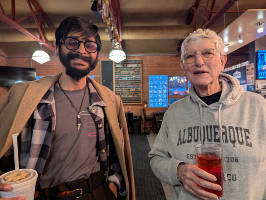 A younger man and an older man in a bar.
