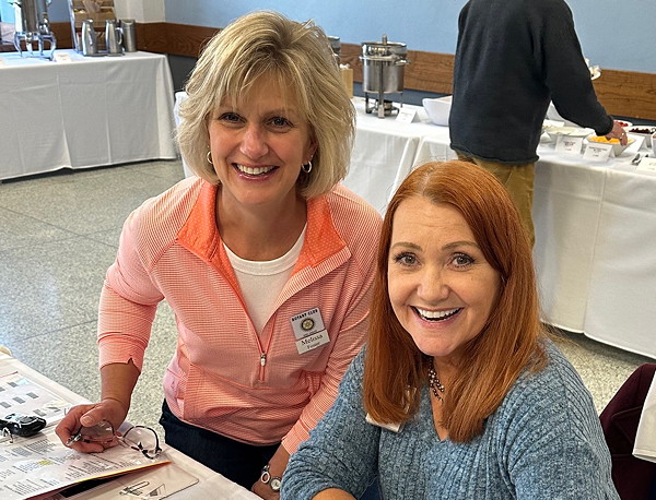 Two women, smiling.