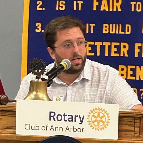 Man speaking into microphone at podium.