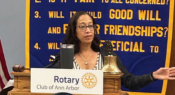 Woman at podium, speaking into microphone.