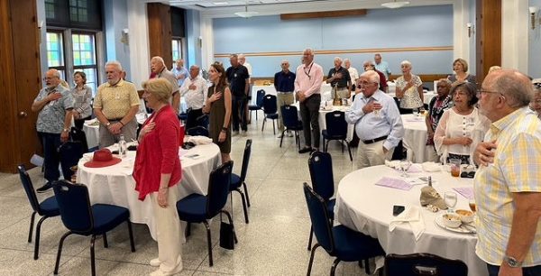 Rotarians standing and singing a patriotic song.