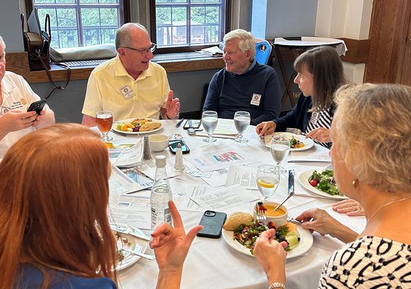 People seated around a table enjoying a conversation at lunch.