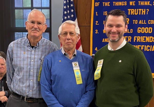 Three men, standing together, smiling at the camera.