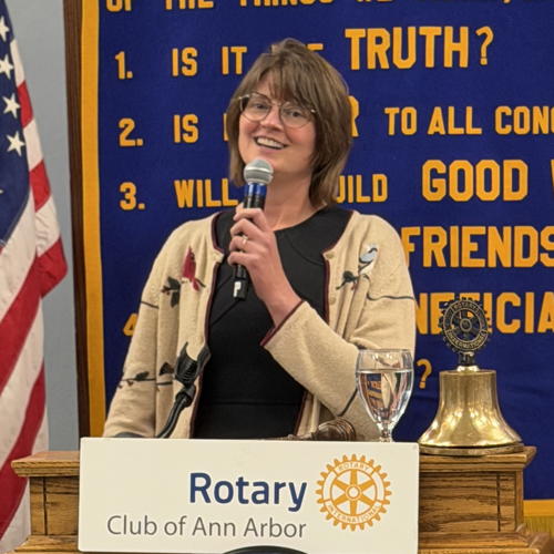 Woman speaking into a microphone.