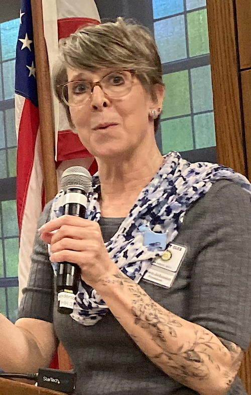 Woman speaking into microphone.