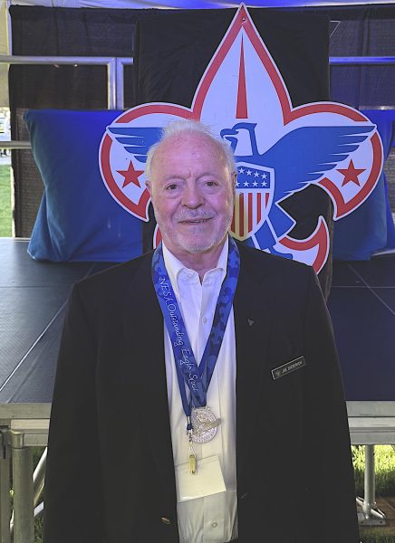 Man standing in front of a Scouting banner.